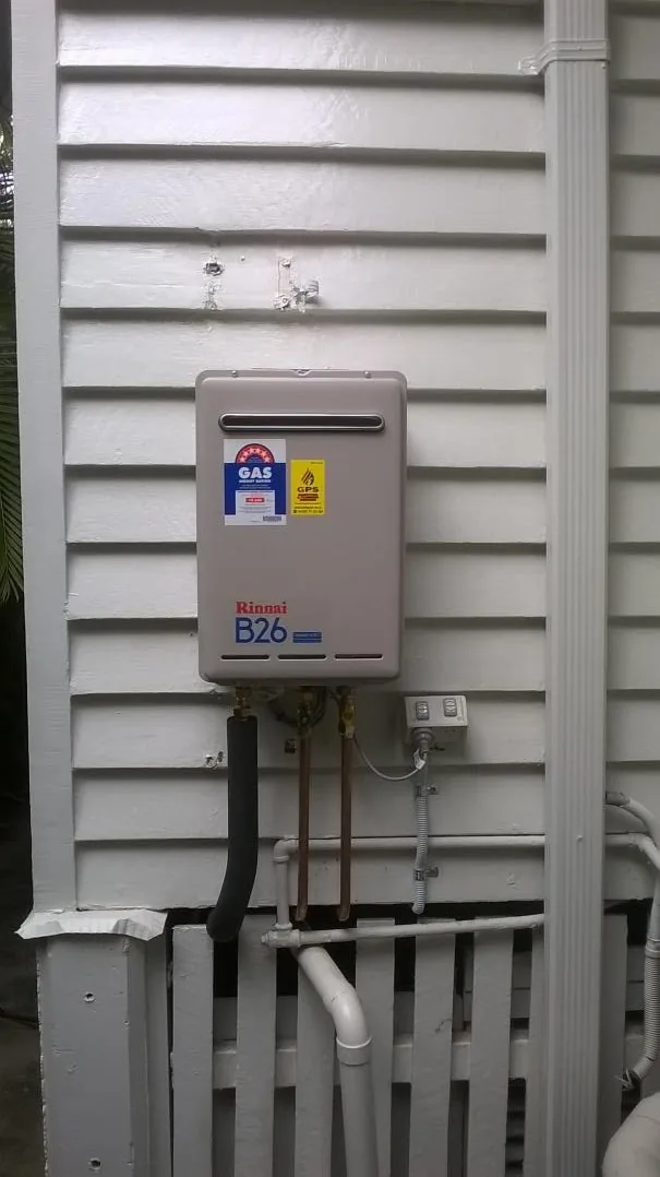 Rinnai B26 continuous-flow gas hot water unit on a weatherboard wall with new copper pipework